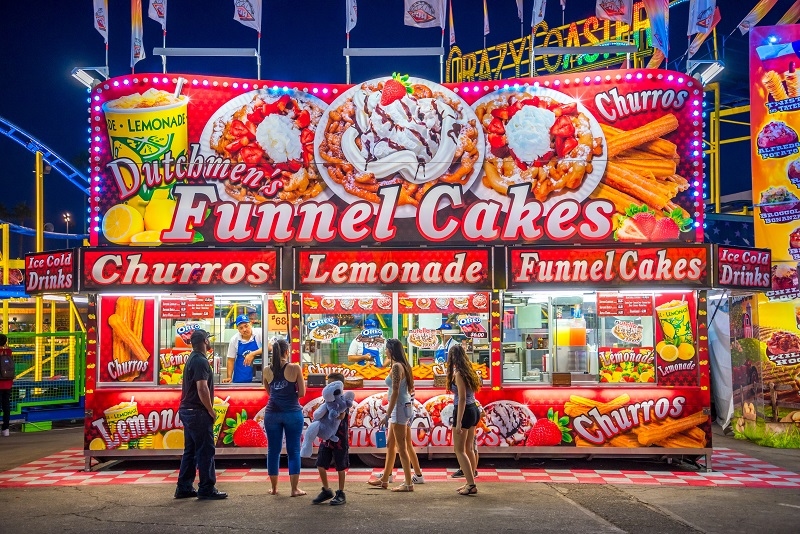  Arizona State Fair lines up at a concession stand selling funnel cakes, churros, and lemonade.