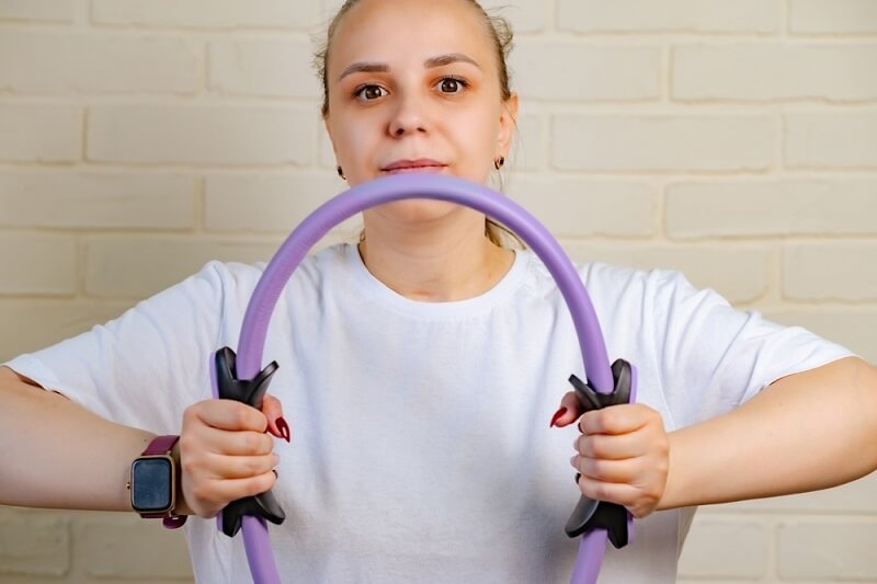 woman training for strength with pilates ring