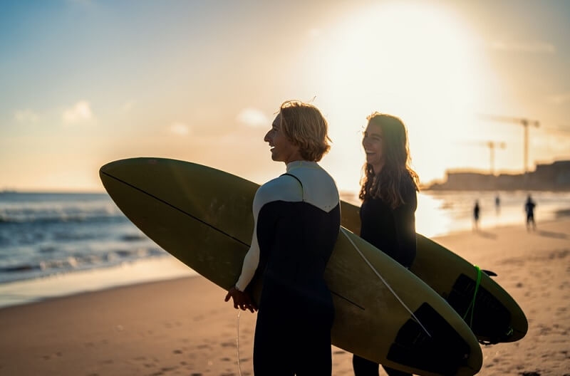 couple on portugal beach for surfing