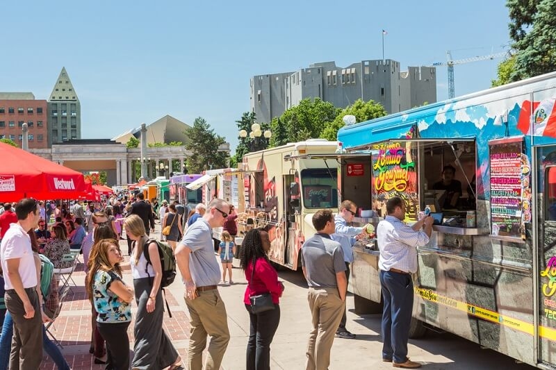 people standing in a queue to get popular food from food truck
