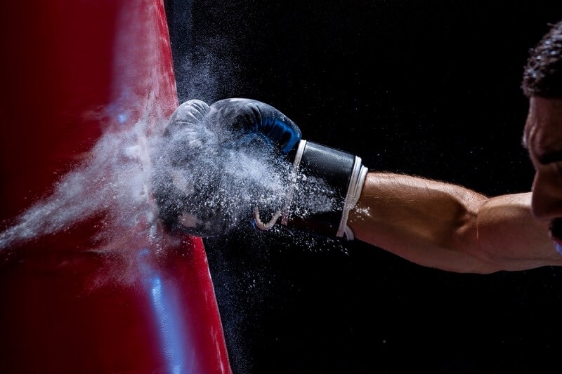 boxer practicing with heavy punching bag
