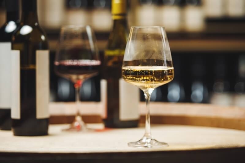 red wine in glass with bottle in background