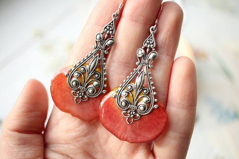 woman holding floral resin earring