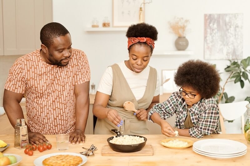 family making jollof rice in kitchen