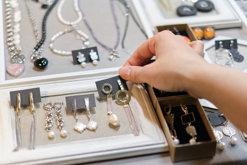 woman selecting jewelry from store
