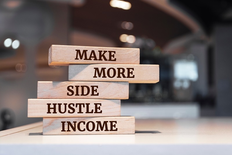 Wooden blocks with words 'Make more side hustle income'.