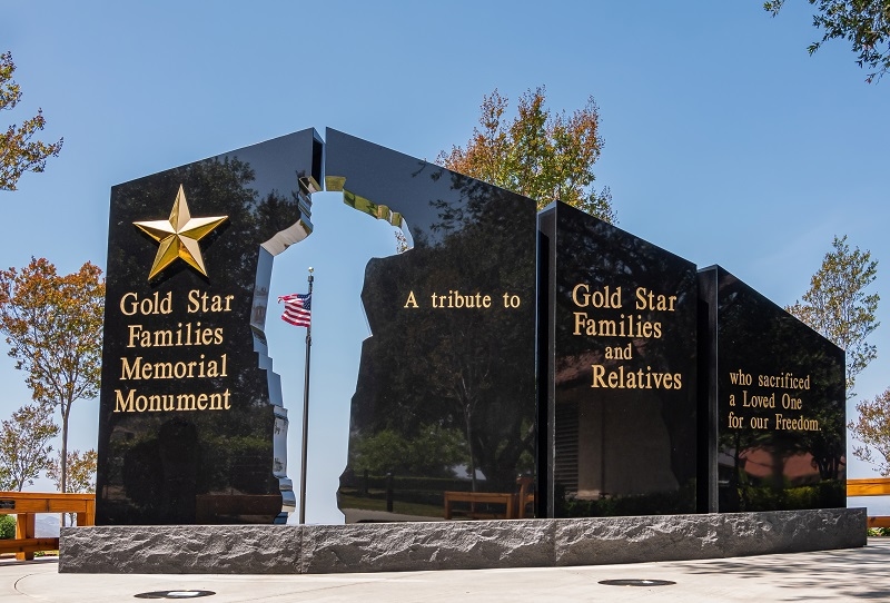 Ronald Reagan Presidential Library. Fisheye view, Gold Star Memorial Monument in green garden is black statue with text and silhouette of saluting soldie