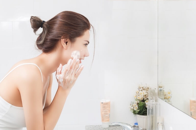 woman cleansing the face before skincare routine