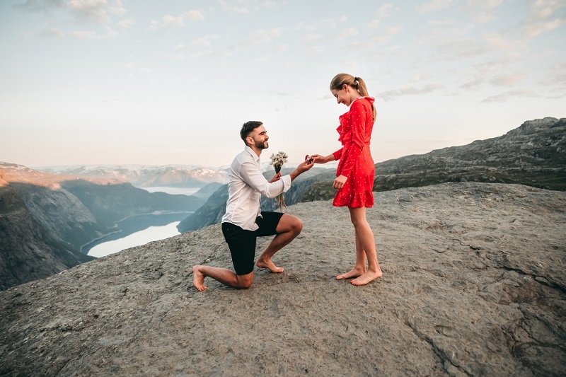 man proposing his girlfriend over the mountain