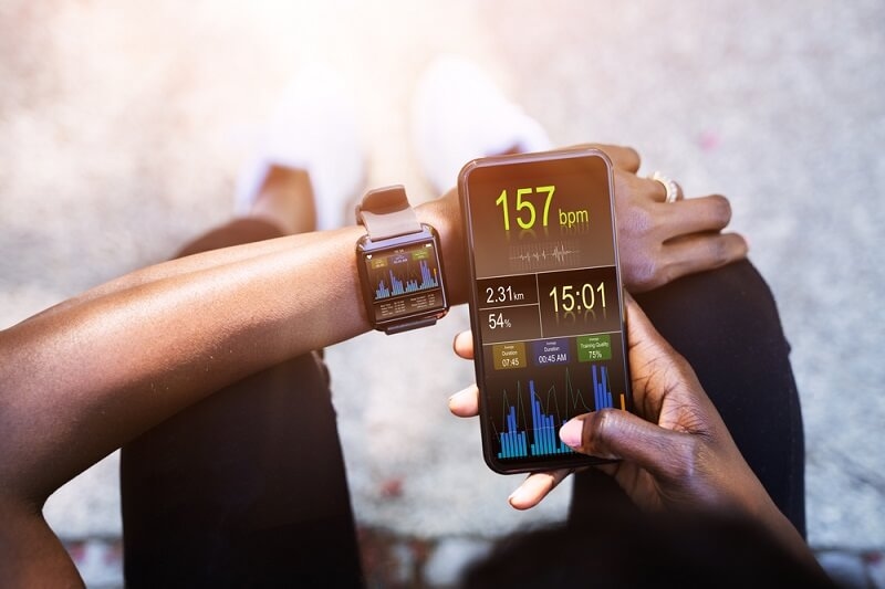 female athlete connected her smartphone with smartwatch