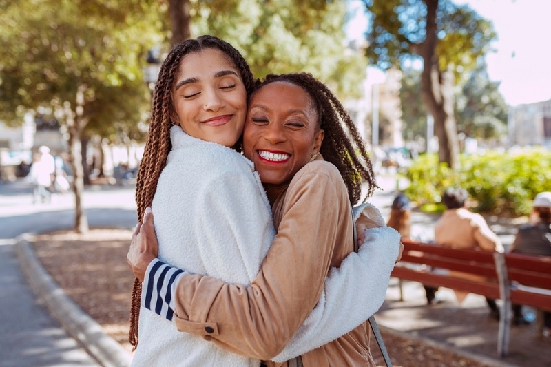 two women happily hugging
