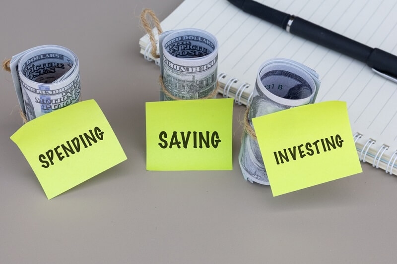 spend savings investing with dollar notes and pen on table