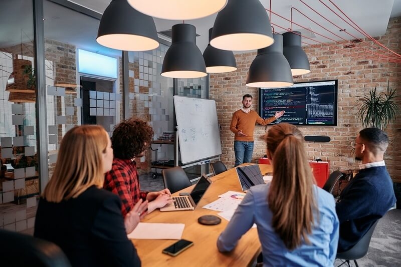 man standing explaining all work details with team
