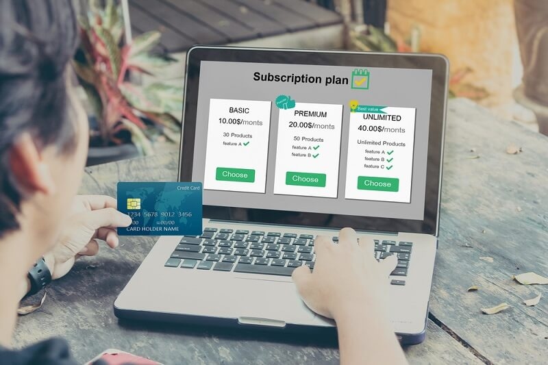 man choosing and buying subscription plans on laptop