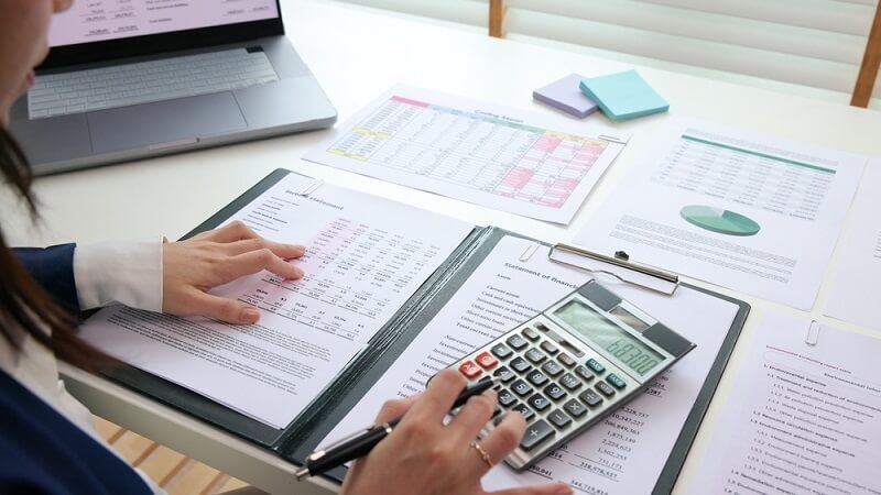 woman checking tax credit and deductions manually from file