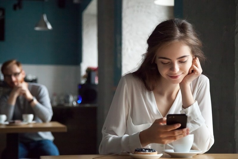 woman smiling and texting to her friend