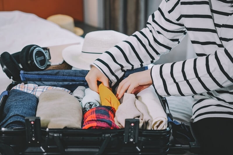 woman packaging all her stuff in bag 