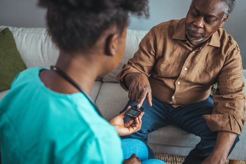 man checking his diabetic level with help of nurse