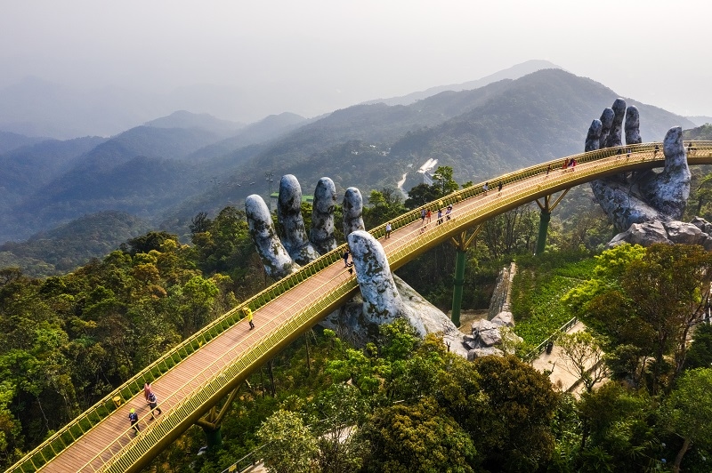Golden Bridge is lifted by two giant hands in the tourist resort on Ba Na Hill in Danang, Vietnam
