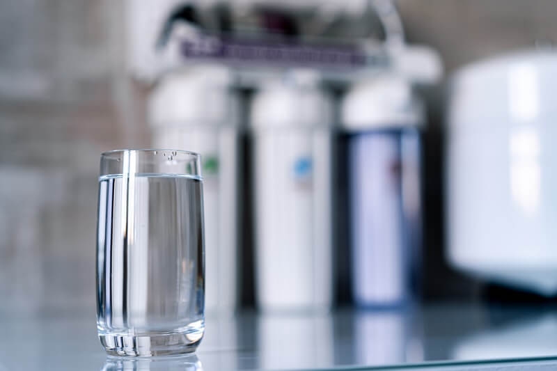 water glass and water filter system in background