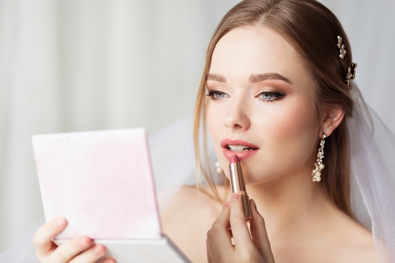 bride applying makeup
