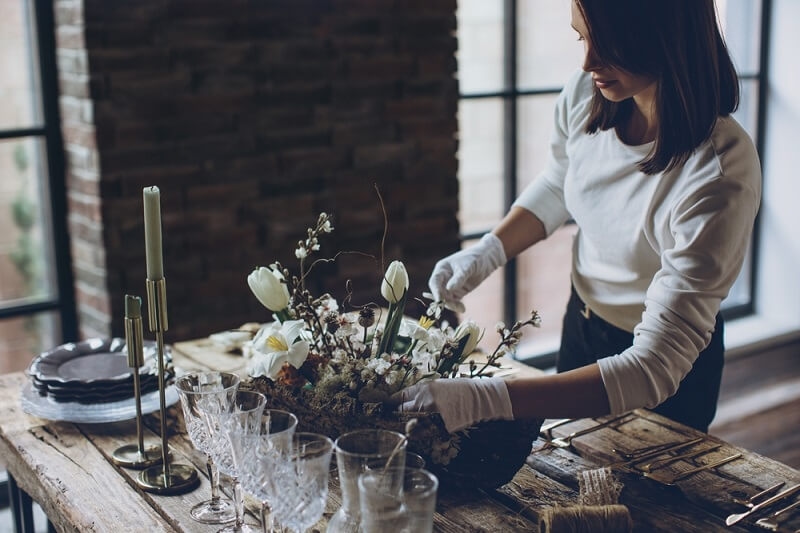wedding vendor woman checking on floral decoration