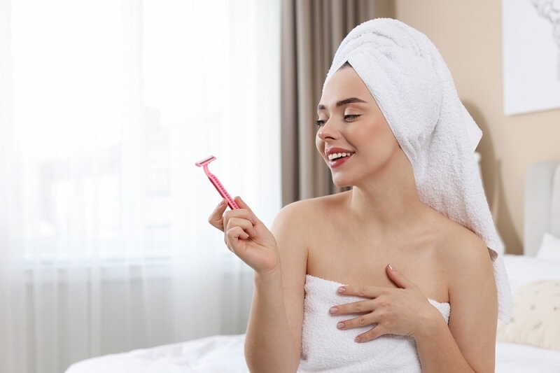 woman after shaving her facial hair holding razor