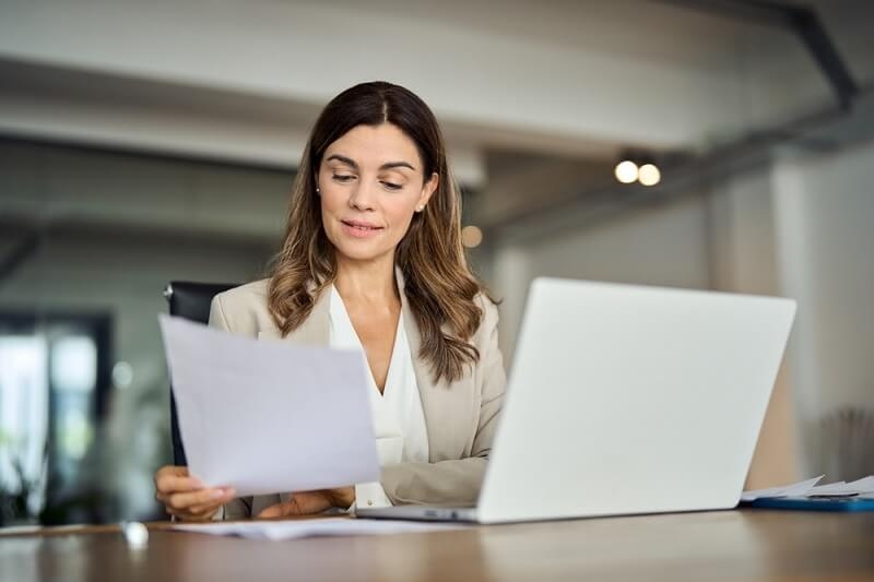 business woman checking her accounts and matching it with papers