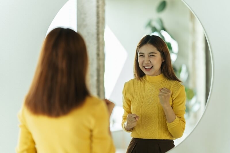 woman  in front of mirror building confidence