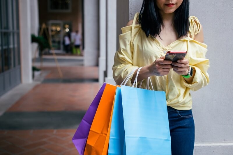 woman with shopping bags checking consumer rights 