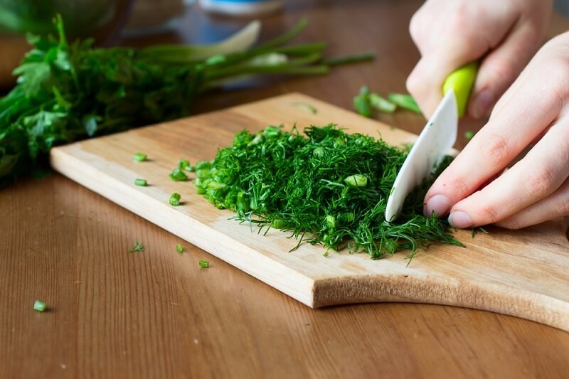 woman cutting fresh herbs