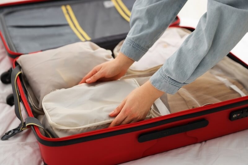 woman packing her stuff in bag with packing cubes