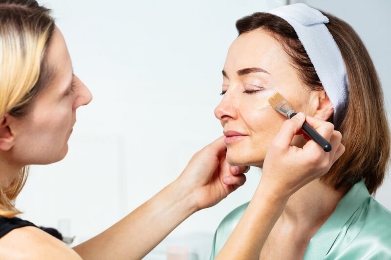 woman applying primer on face