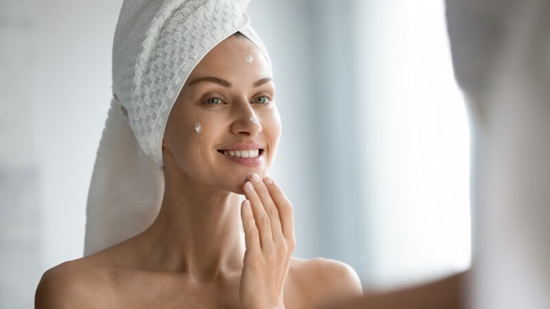 woman applying light tinted moisturizer  after taking bath