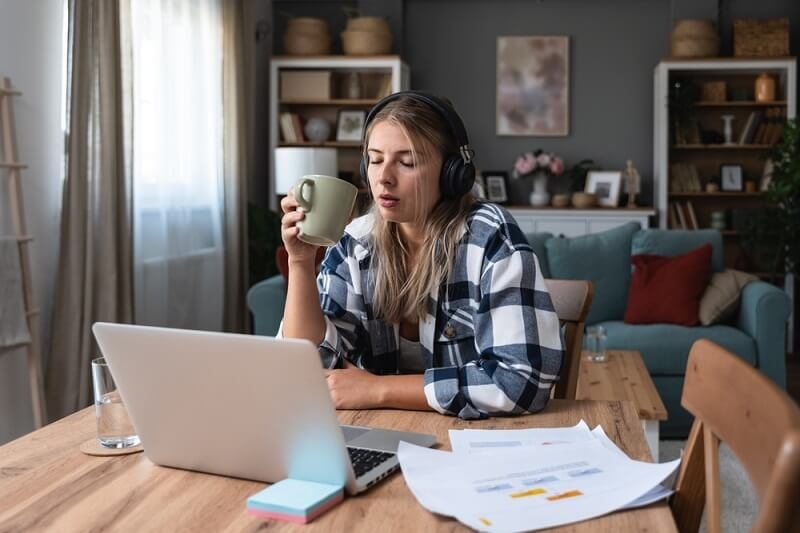 woman holding cup of tea and working on part time customer service jobs