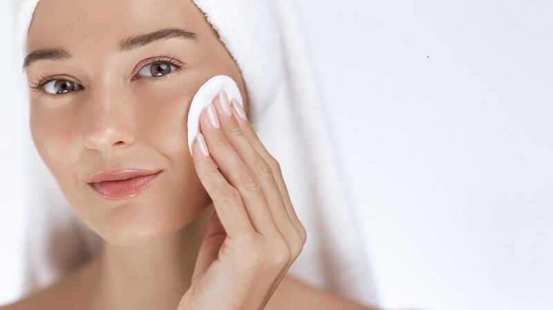 woman cleansing her face gently