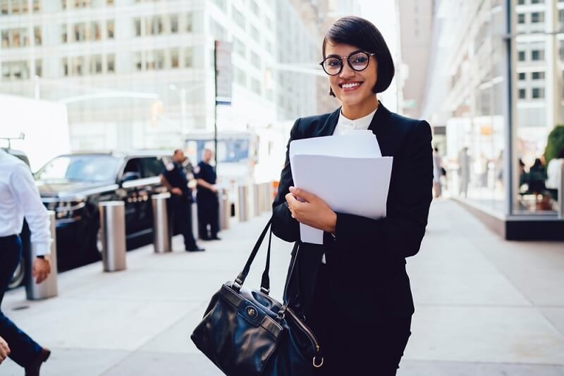 woman in formal holding tote bag