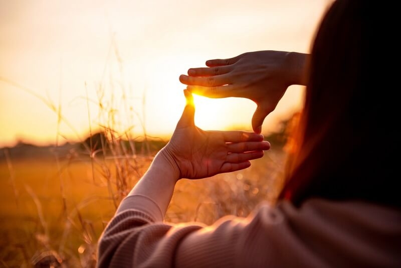 girl framing a shot through her hands