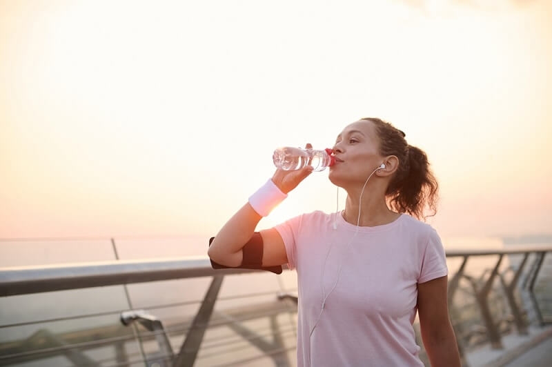 women drinking water after exercise routine
