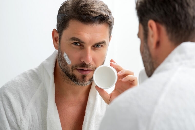 young man cleansing his face