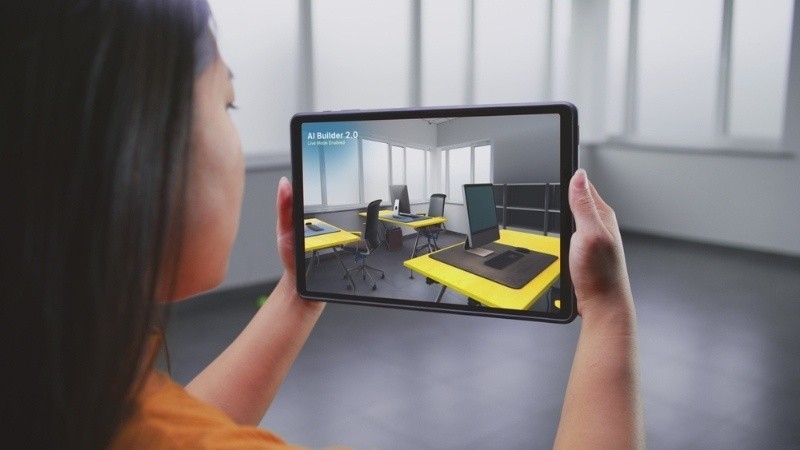 Asian female designer uses tablet computer and virtual reality interior design app to design office workspace.