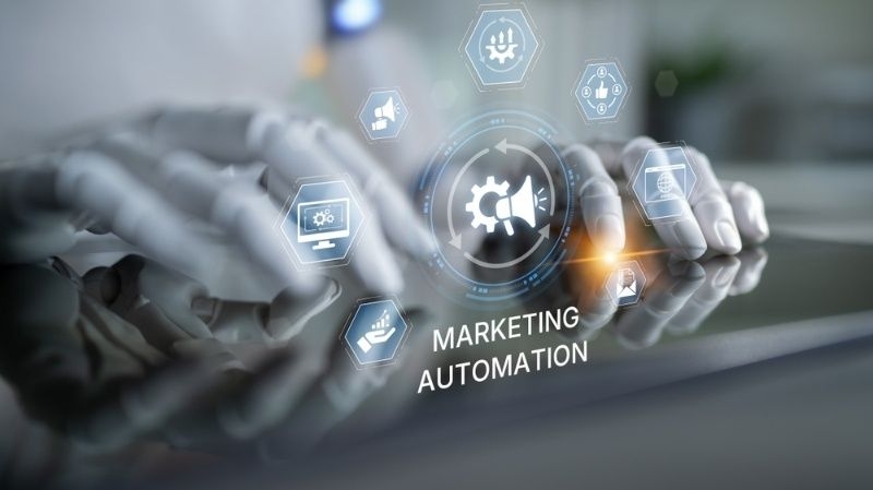 Robot hands using a touchscreen with marketing automation interface and digital icons.