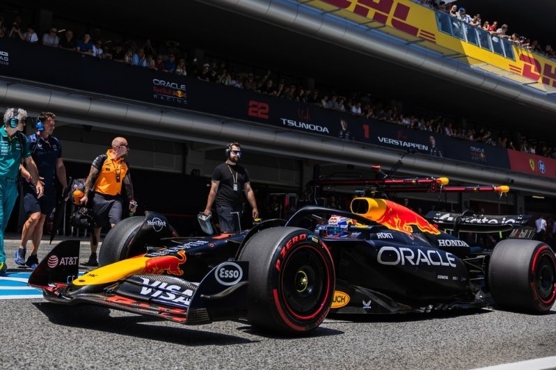 Oracle Red Bull Racing Formula One car parked in the pit lane with team members and spectators in the background.