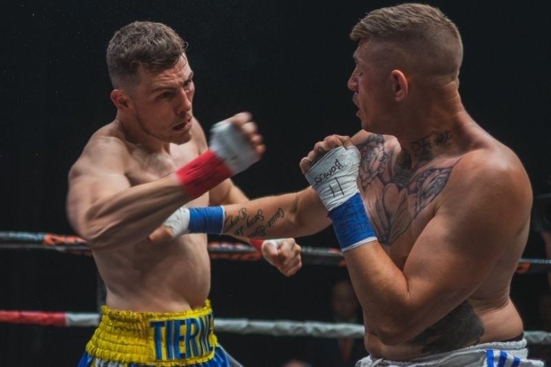 Two boxers exchanging punches during a professional boxing match inside a ring.