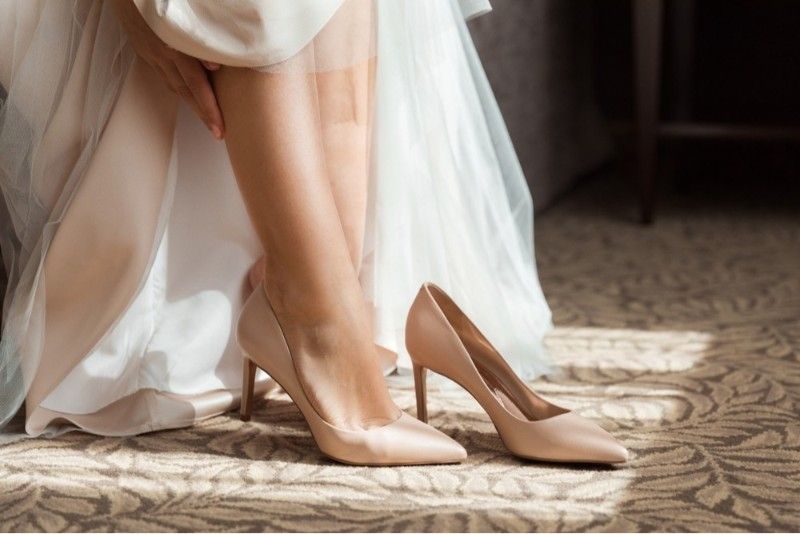 Bride Putting on Shoes. Bride putting on wedding shoes at home 