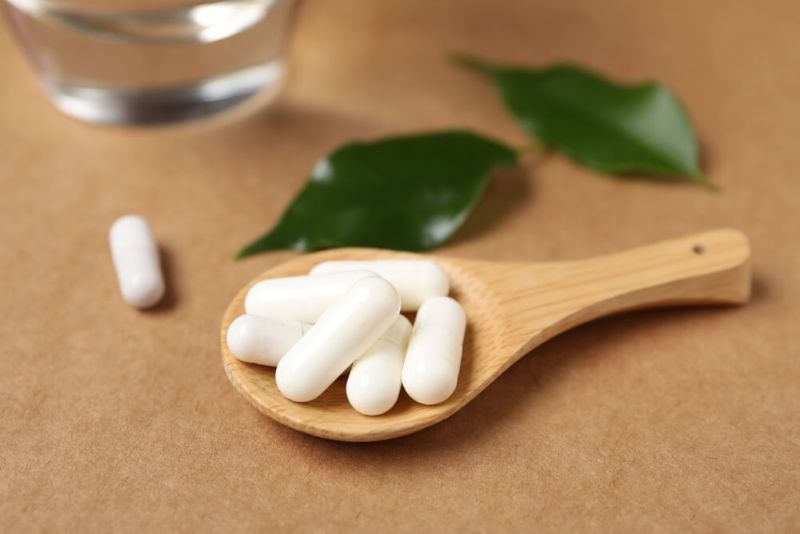 Collagen capsules on a wooden spoon