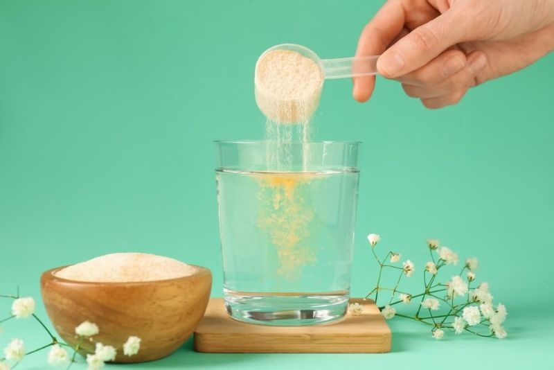 Women pouring Collagen powder into a glass of water