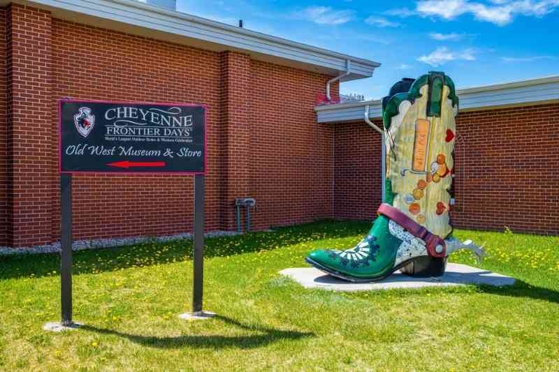Cheyenne Frontier Days museum sign beside a large decorative cowboy boot sculpture.