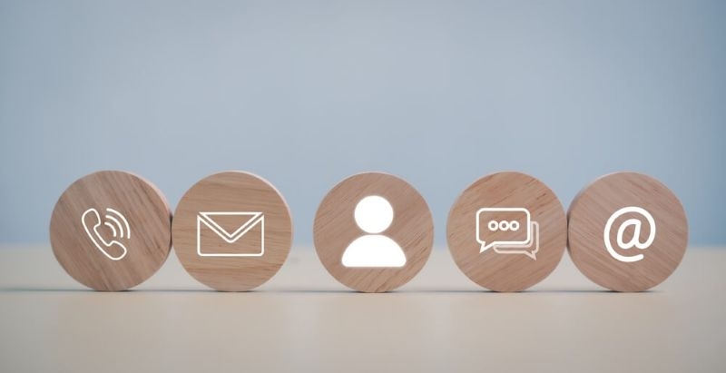 wooden blocks with icons of call, email, user, messages and @ symbol