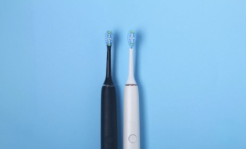 black and white electric toothbrushes kept side by side